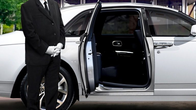Chauffeur,Standing,Next,To,Opened,Car,Door,With,Red,Carpet